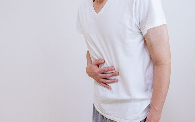 胃の不調を感じる男性